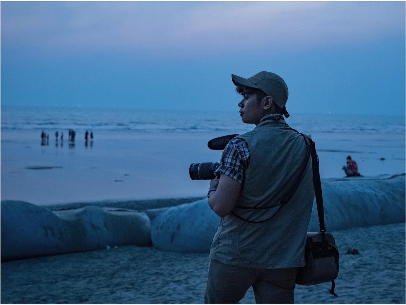 Narita Jun with his camera on a beach in Cox's Bazar at dusk