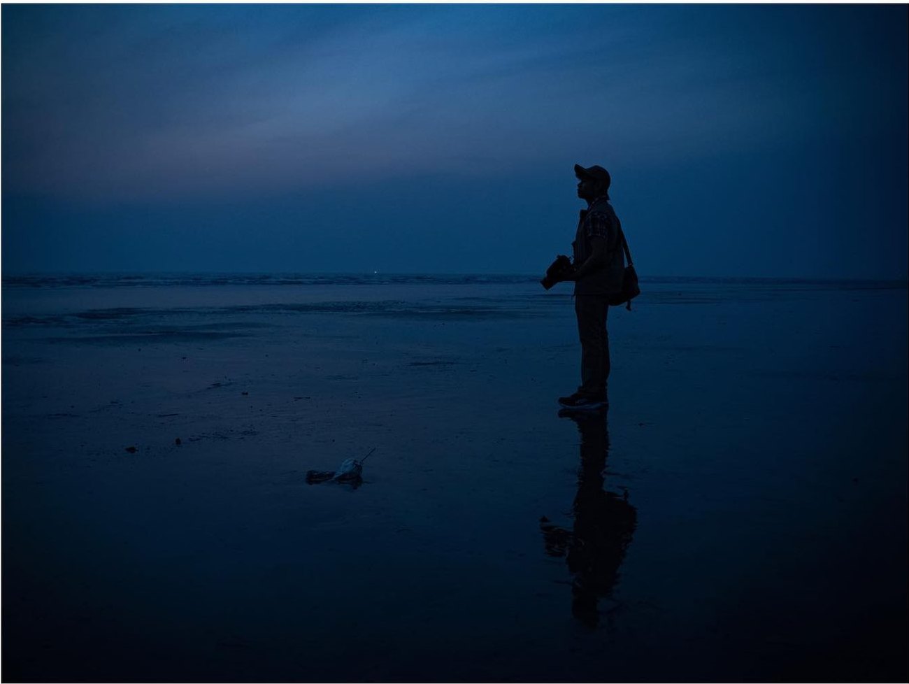 A figure on the beach before dawn