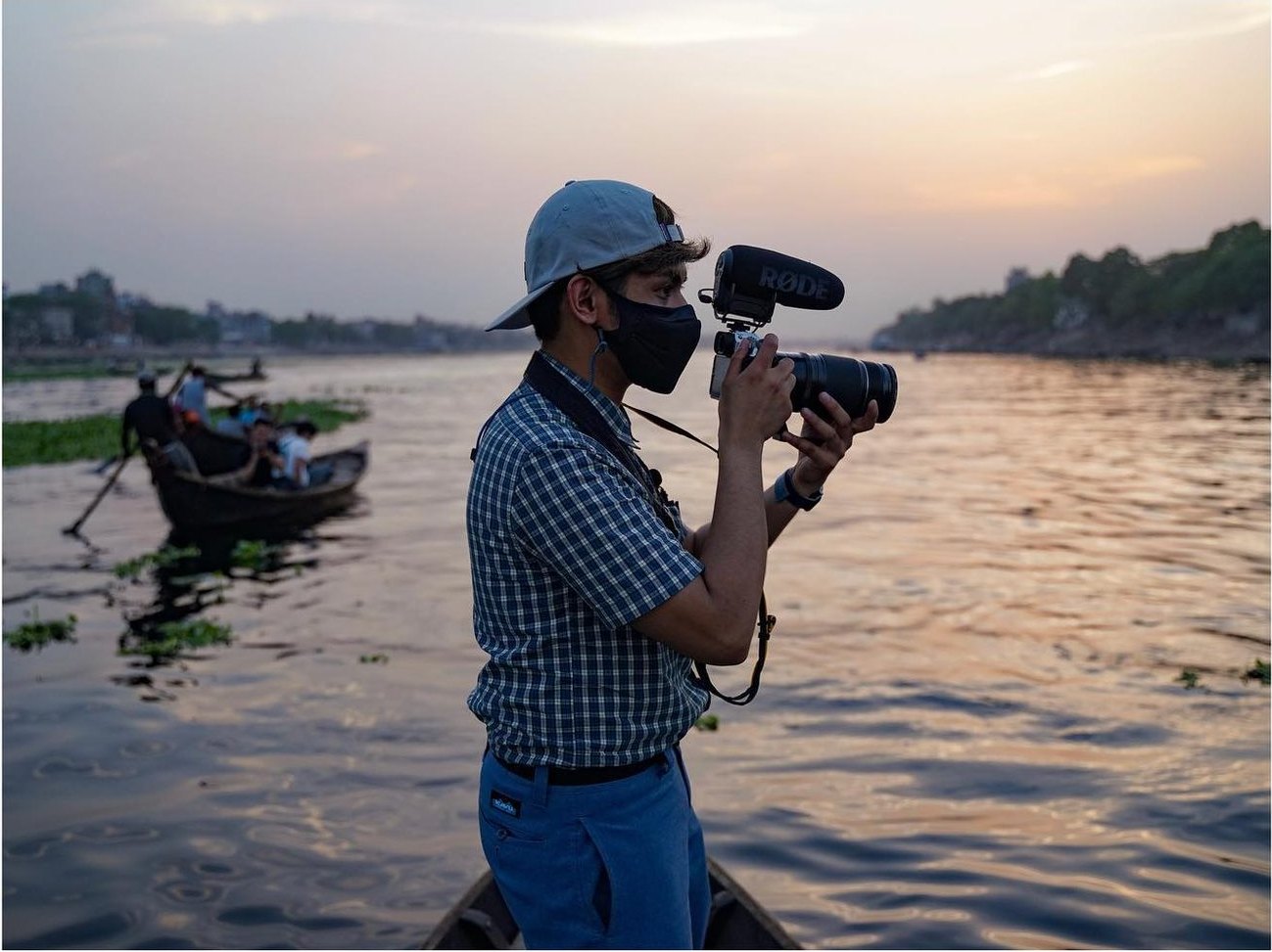 Narita Jun filming from a boat on a river at dusk