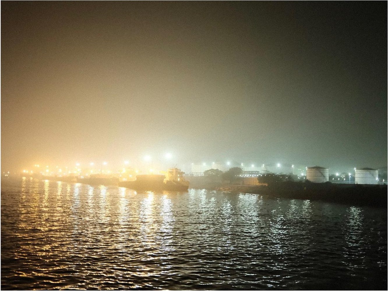 Harbor lights glowing in the night fog