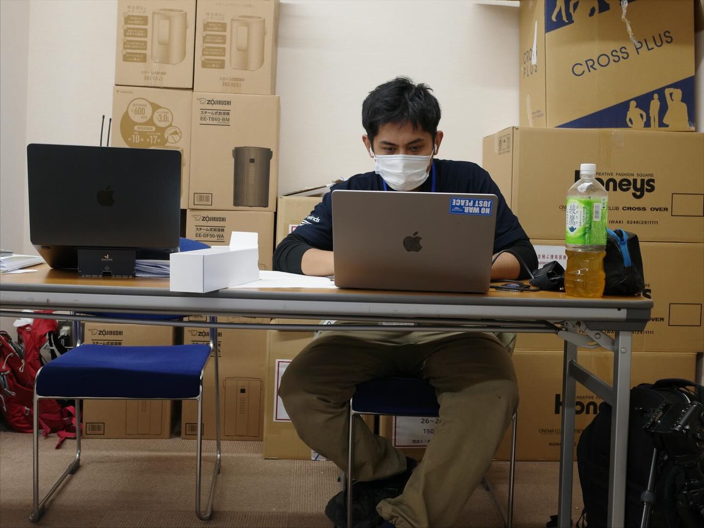 Narita Jun writing up his notes in a corner of an evacuation center