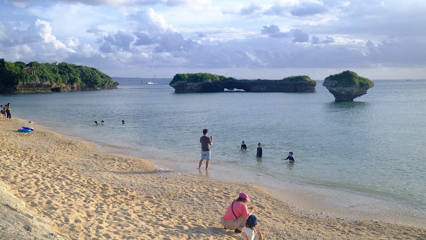 A beach in Okinawa with rocks in the water