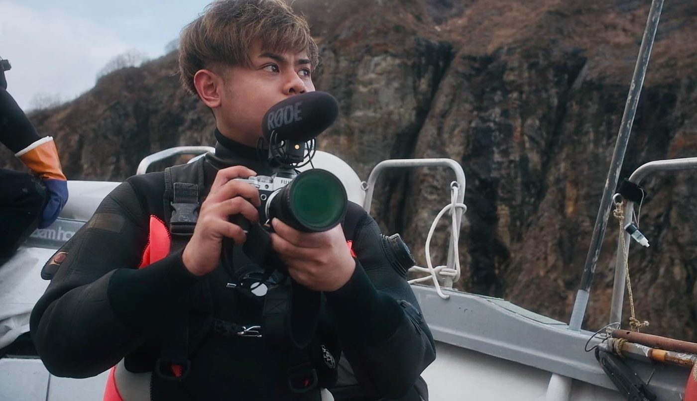 Narita Jun filming from a boat in the sea off Shakotan