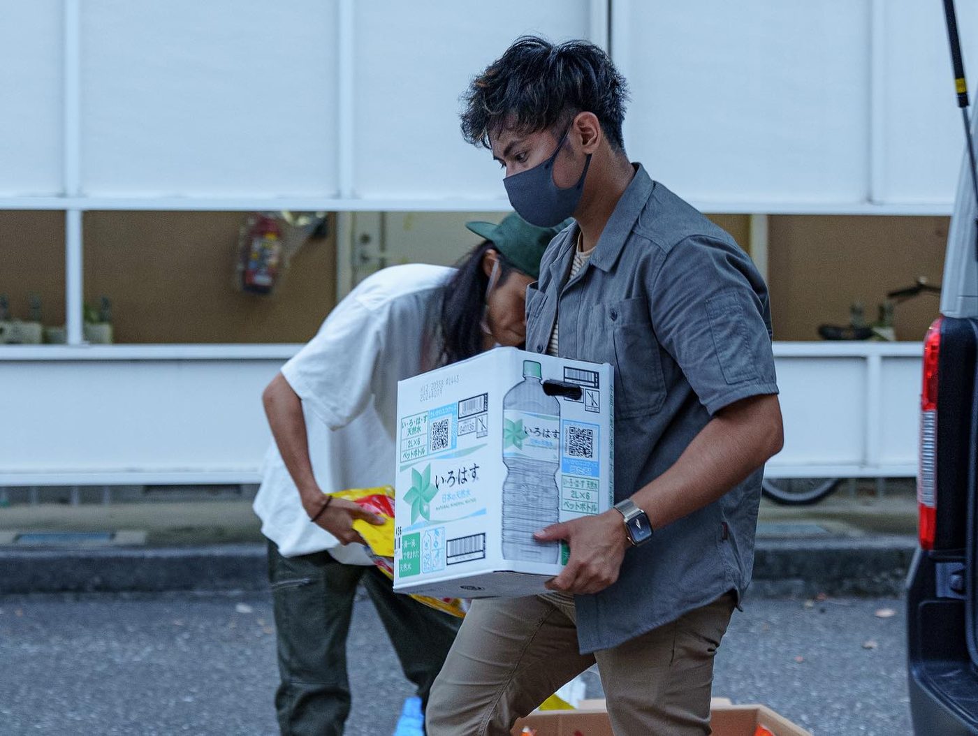 Narita Jun carrying boxes of relief supplies