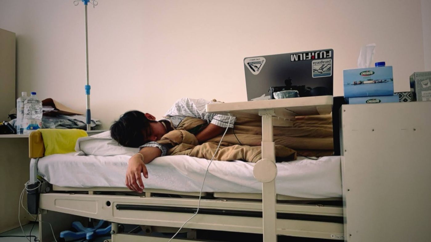 Narita Jun lying in a hospital bed in Bangladesh