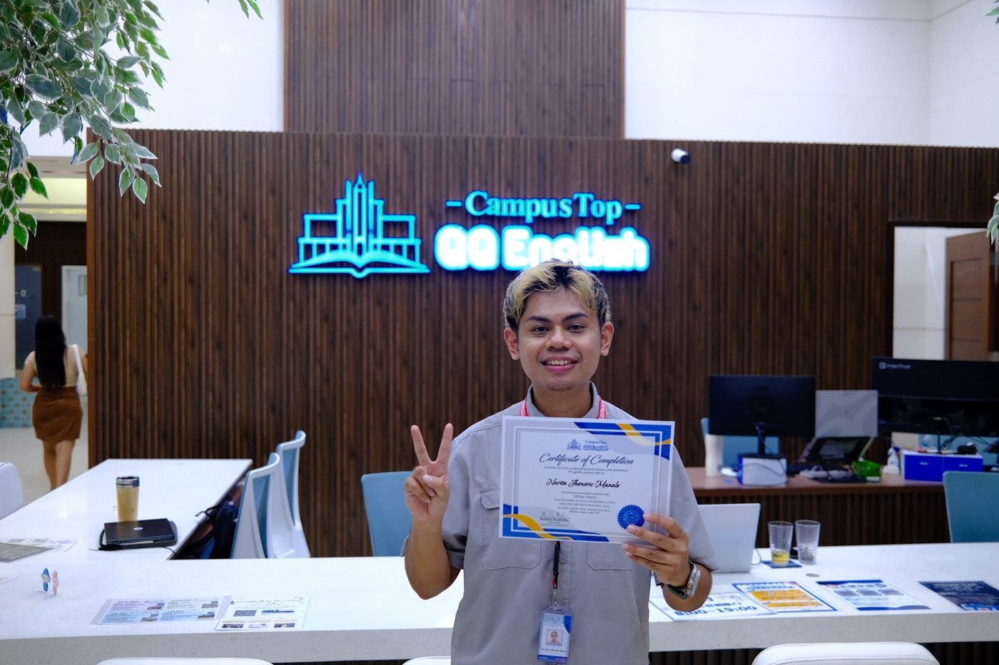Narita Jun holding his language school certificate